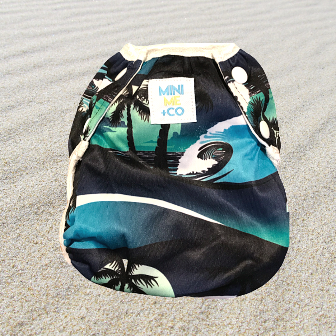 Mini Me & Co reusable swim nappy featuring a vibrant palm tree print, adjustable for a snug fit, ideal for eco-friendly parents.