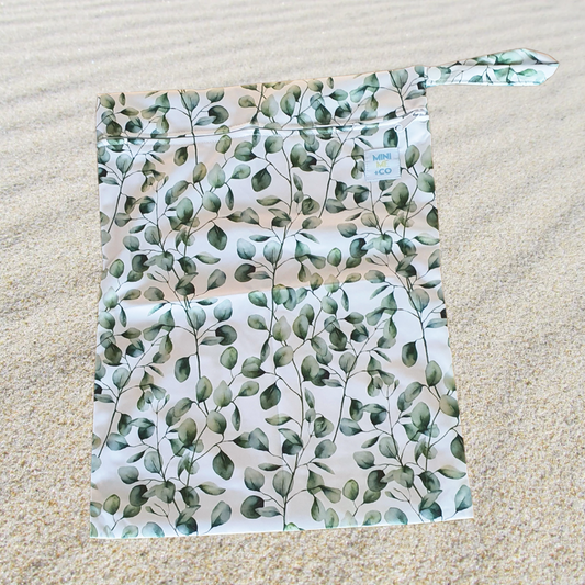 A stylish Eucalyptus Leaves Wet Bag made from 100% PUL material, measuring 25cm (H) x 20cm (W). Featuring a reliable zipper closure, it keeps wet items contained and secure. The bag includes a convenient latch for easy attachment to strollers or bags, making it perfect for transporting swimwear, dirty clothing, nappies, or toiletries. Eco-friendly and reusable, this wet bag is easy to clean and complements our Reusable Swim Nappies for a coordinated look.