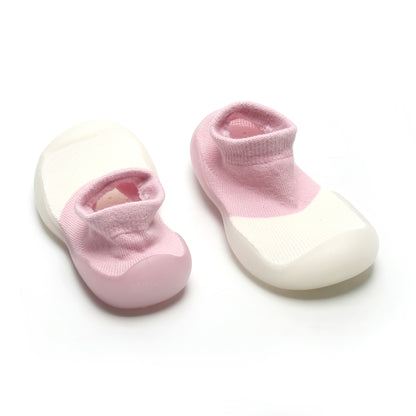 Stylish pink and white sock shoes for pre walkers, featuring a non-slip rubber sole for stability.