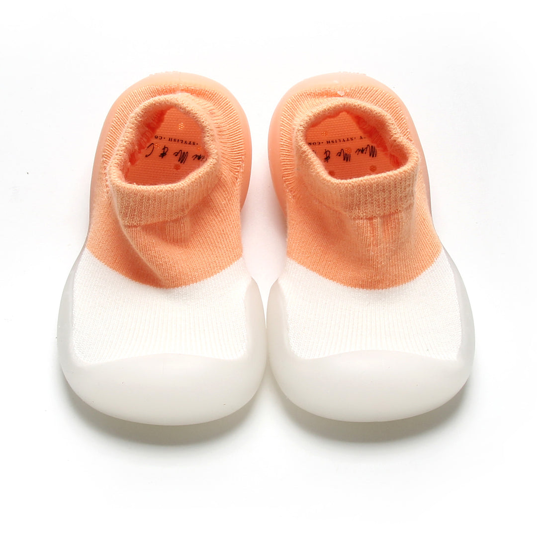 Peach and white sock shoes for kids with soft cotton upper and flexible non-slip sole.