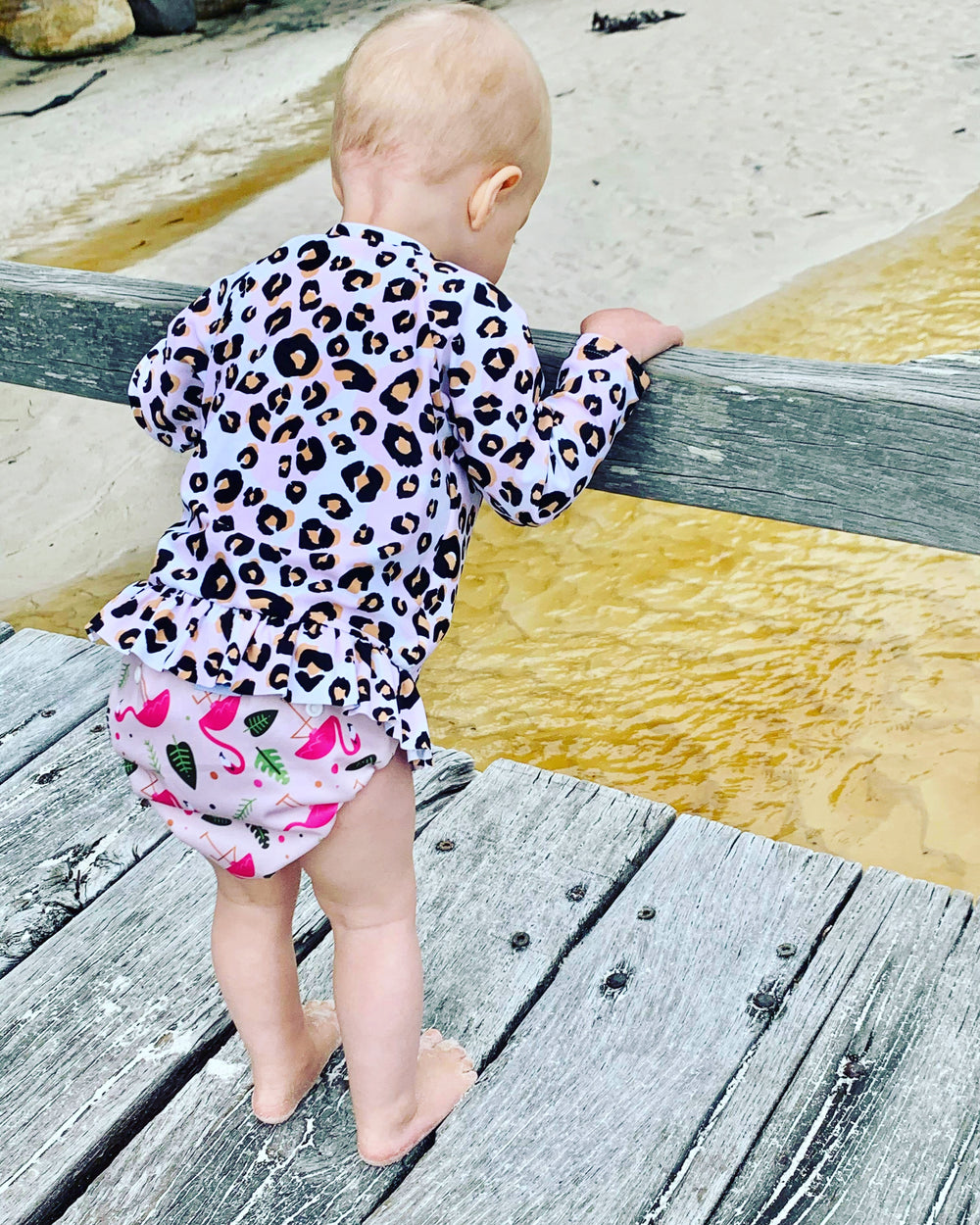 Eco-Friendly Flamingo Swim Nappy: Mini Me & Co reusable swim nappy showcasing a fun flamingo motif, crafted from breathable and waterproof materials.

