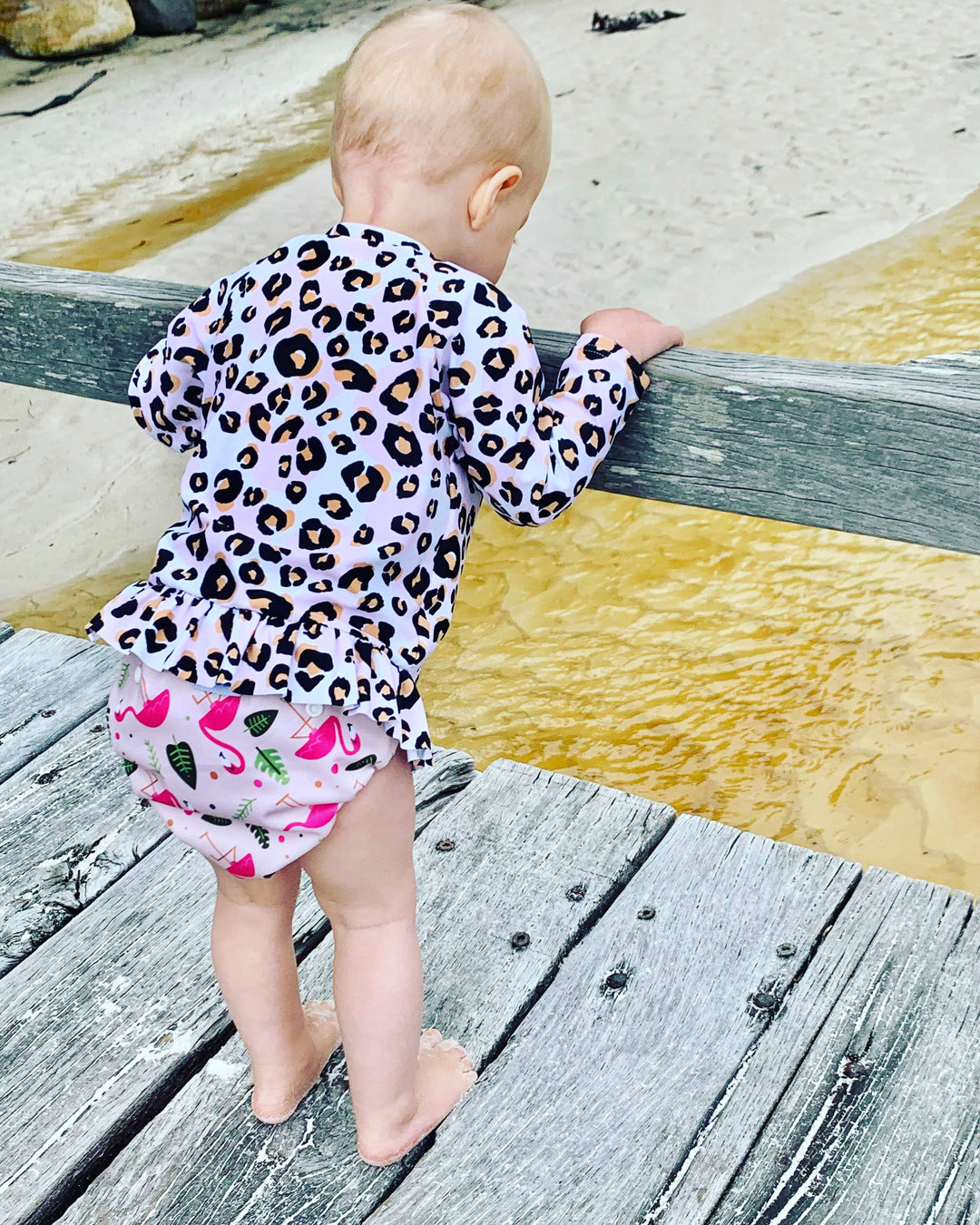 Eco-Friendly Flamingo Swim Nappy: Mini Me & Co reusable swim nappy showcasing a fun flamingo motif, crafted from breathable and waterproof materials.

