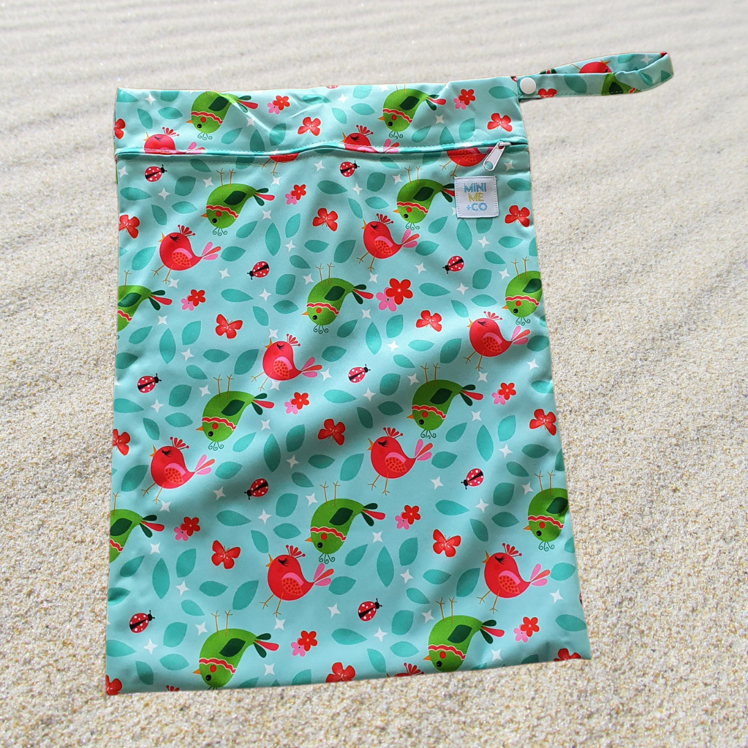 A waterproof wet bag featuring a coloruful bird design. This durable bag is made from 100% waterproof PUL polyester and has a secure zip closure, making it perfect for storing wet swimwear, cloth nappies, or damp items. Ideal for travel and everyday use.