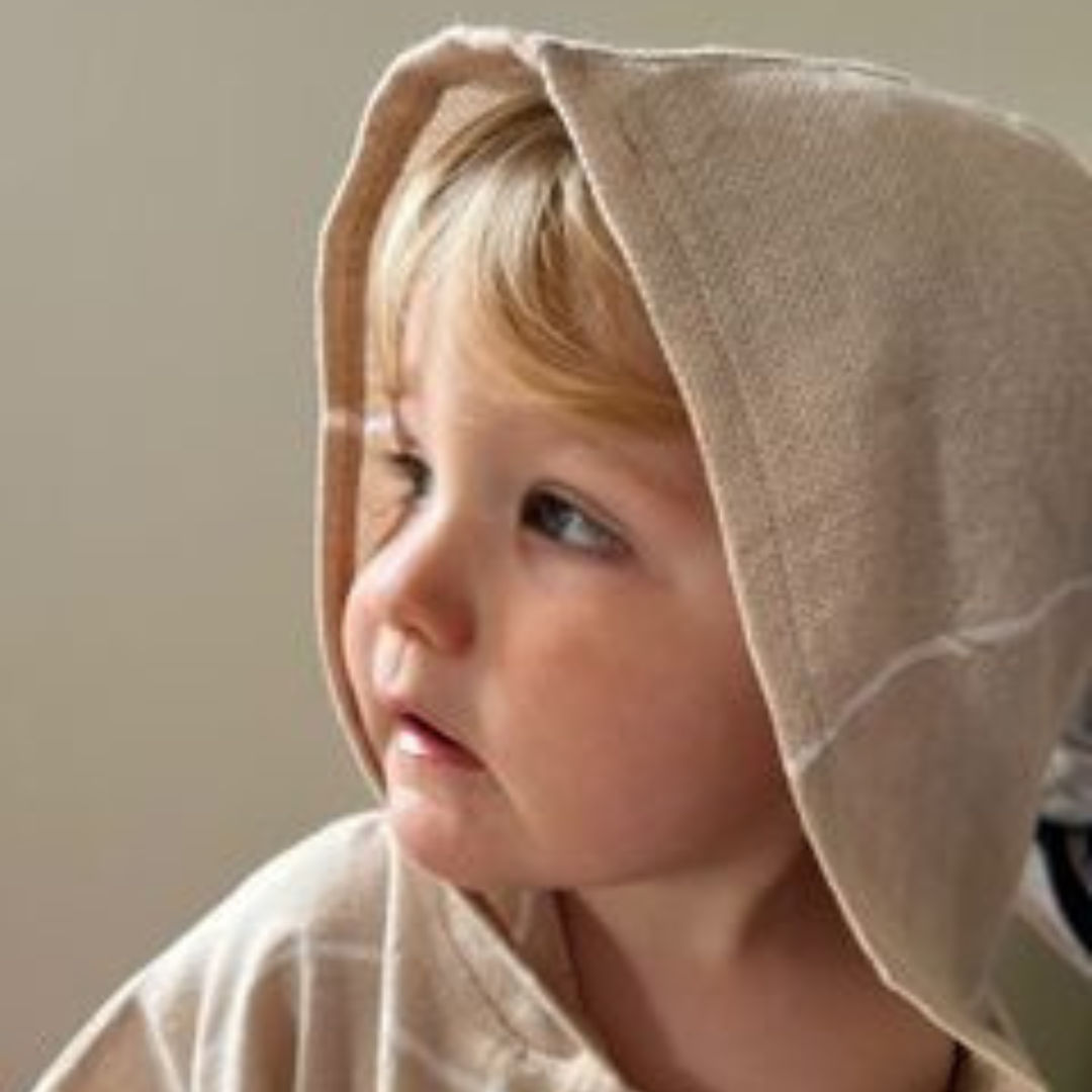 Lightweight kids poncho towel in beige perfect for beach or pool days, offering excellent sun protection