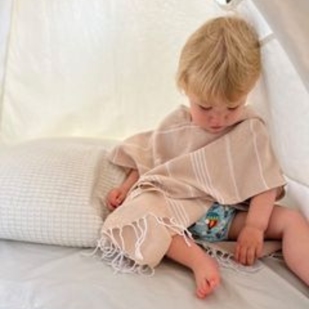 Organic cotton kids poncho towel measuring 60cm wide and 50cm high for ages 1-4, perfect for keeping kids cozy.