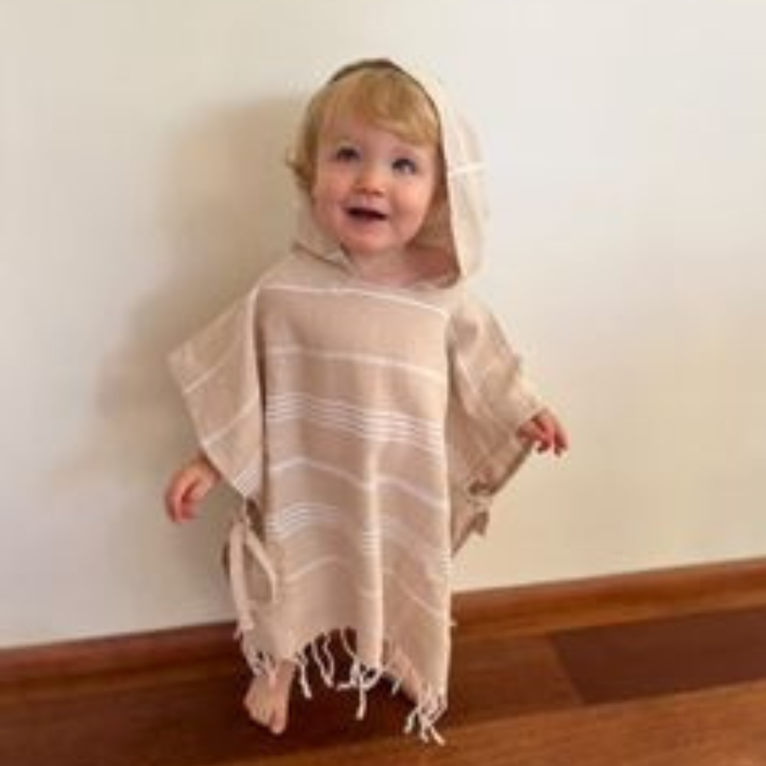 Stylish kids poncho towel, perfect for playtime at the beach or pool, ensuring kids look fashionable while staying dry.