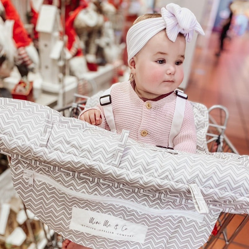 Mini Me & Co Trolley Cover: A vibrant, padded shopping trolley cover designed to protect children from germs while providing comfort and safety during shopping trips.